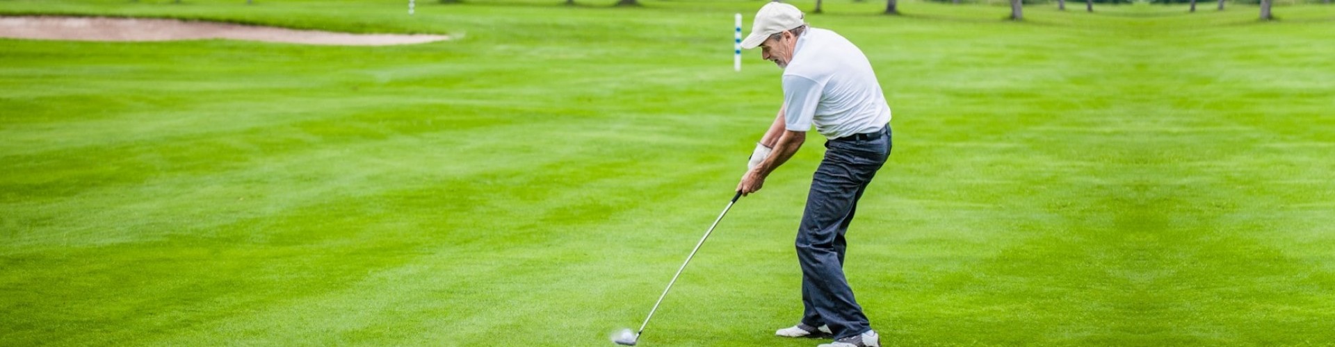 senior man taking a golf swing